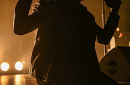 Photo du chanteur des Black Pumas assis sur le devant de la scène du zénith de Toulouse