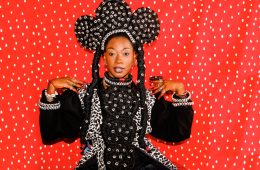 Portrait de Fatoumata DIawara sur fond rouge et costume folklorique
